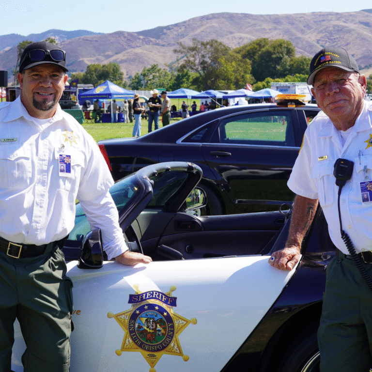 Sheriff’s Auxiliary Volunteer Patrol Members Standing in Front of Car