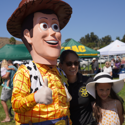 Mother and Daughter posing with Sheriff Woody from Toy Story